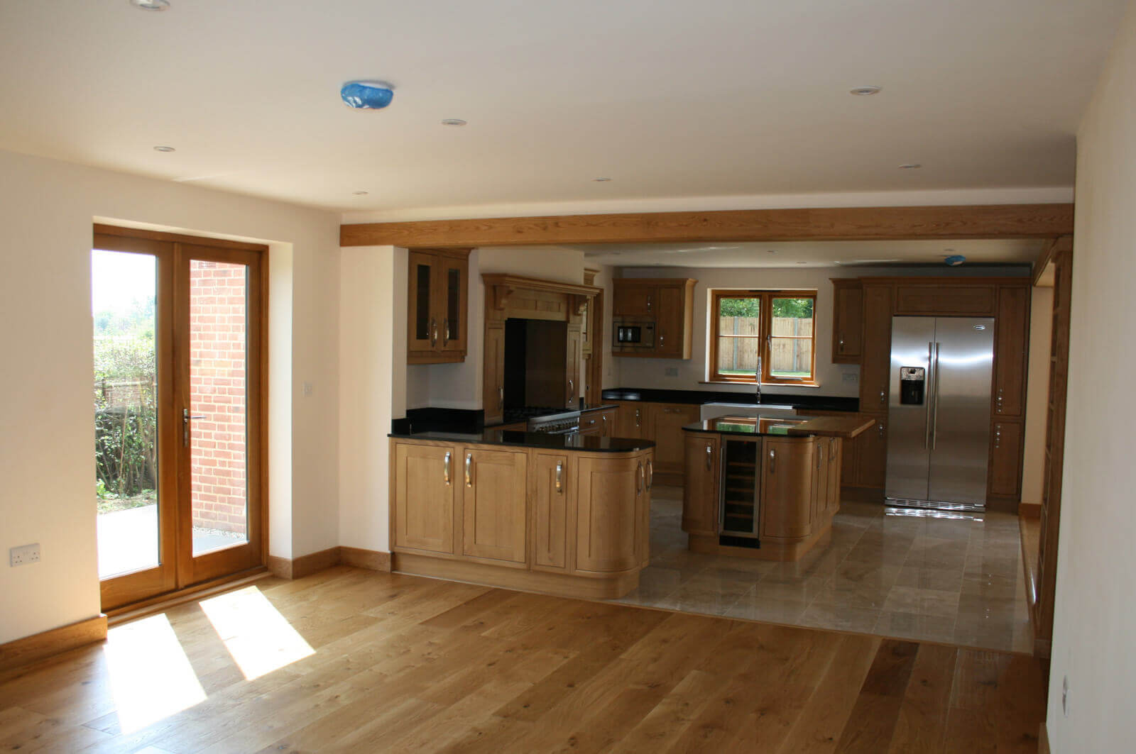 Open plan hard wood floored living room and premium kitchen